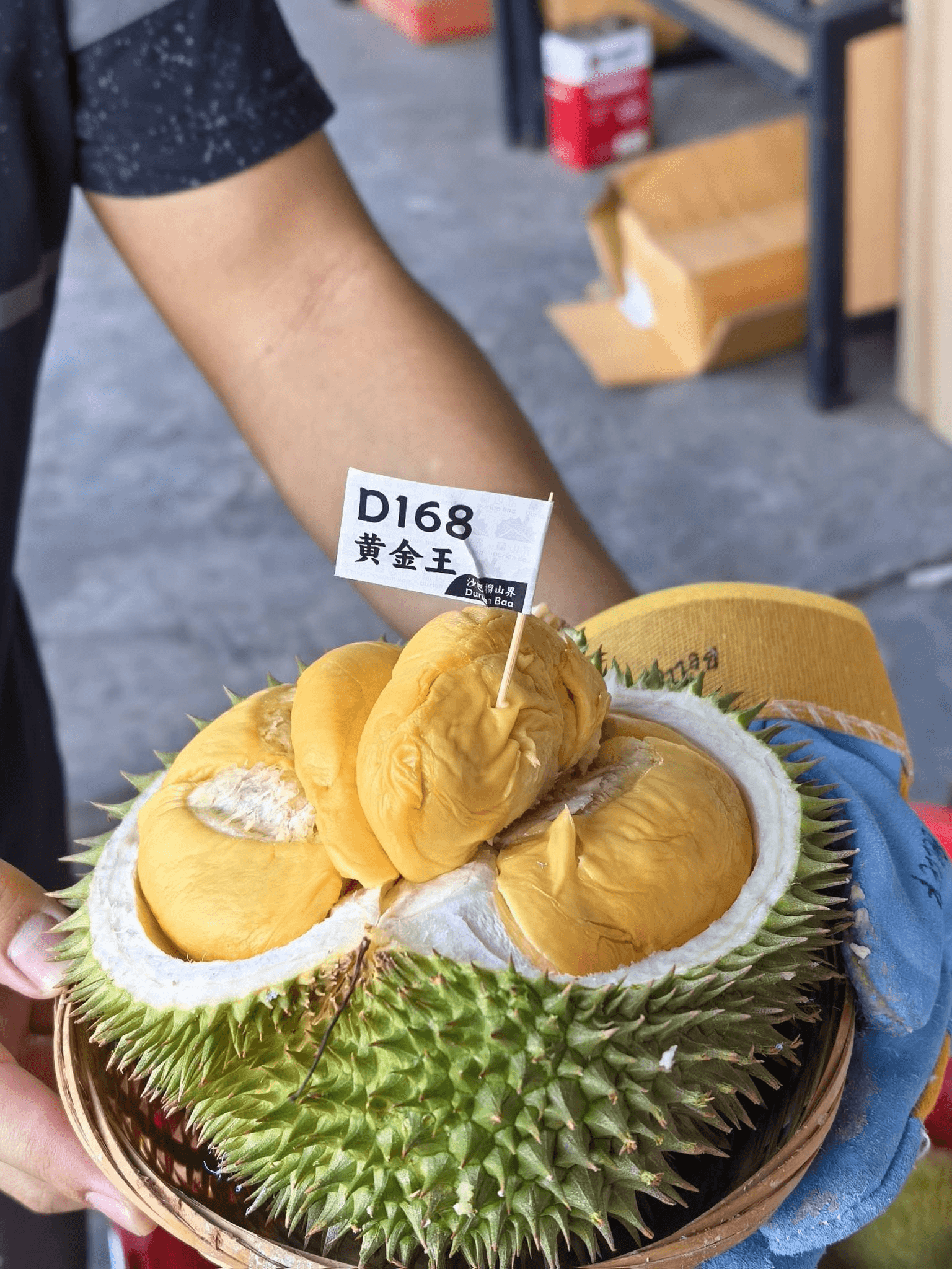 A whole durian opened to reveal golden flesh, marked Golden King.